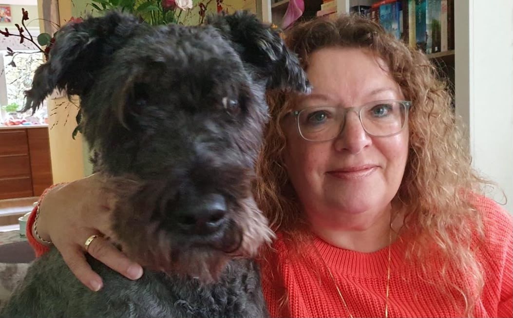 Anja Reijns met haar arm om een donkere hond