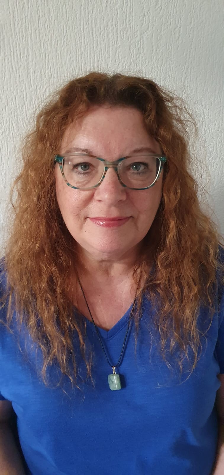 Portret van Anja Reijns, met krullend rood haar en een blauwe blouse